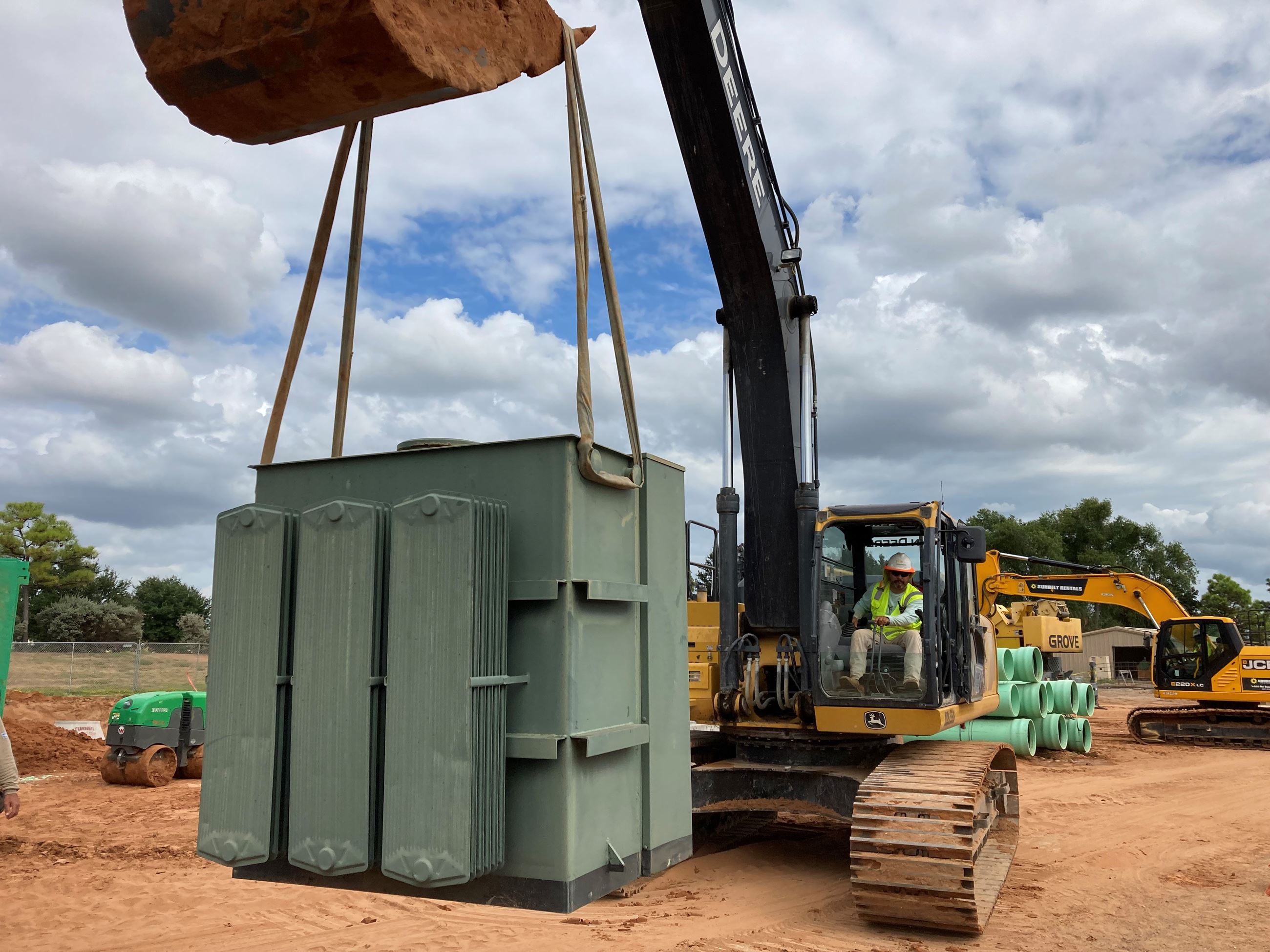 A crane picking up an electric power box.