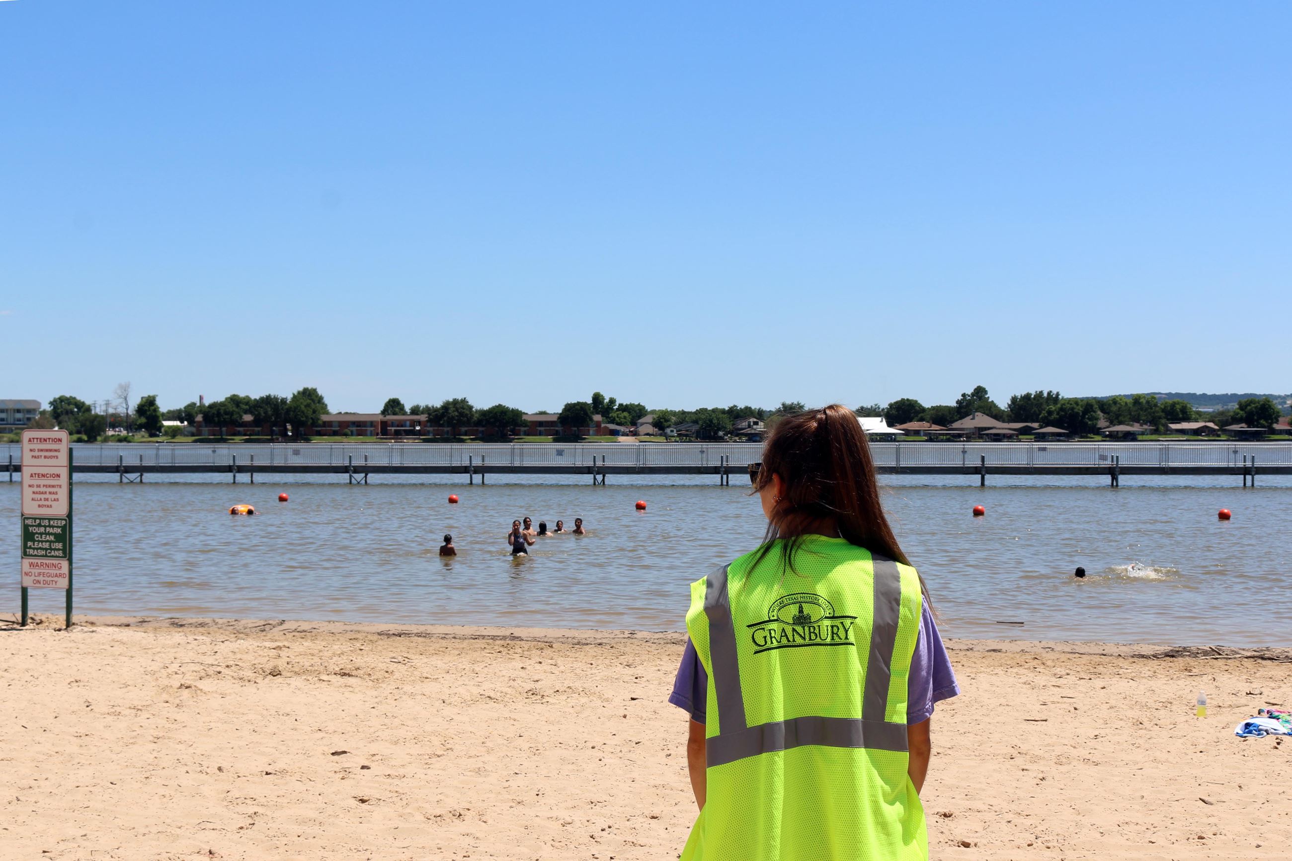 Beach monitor in neon vest standing on City beach.