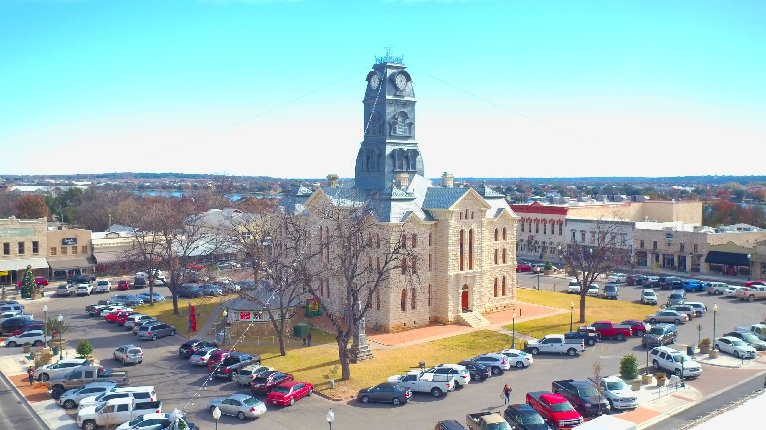 An aerial view of the Hood County Courthouse surrounded with a full parking lot of cars.